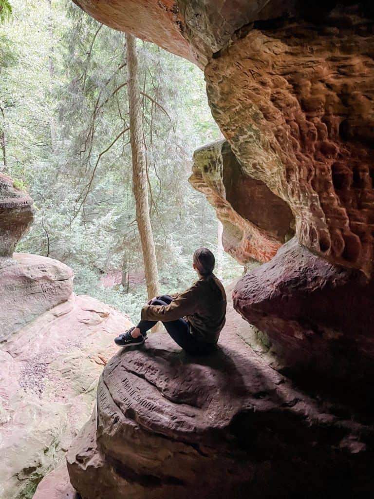 Woman looking out window of Rock House in Hocking Hills