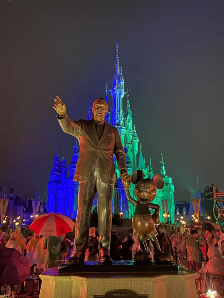 Magic Kingdom Castle with Walt and Mickey statue in the rain