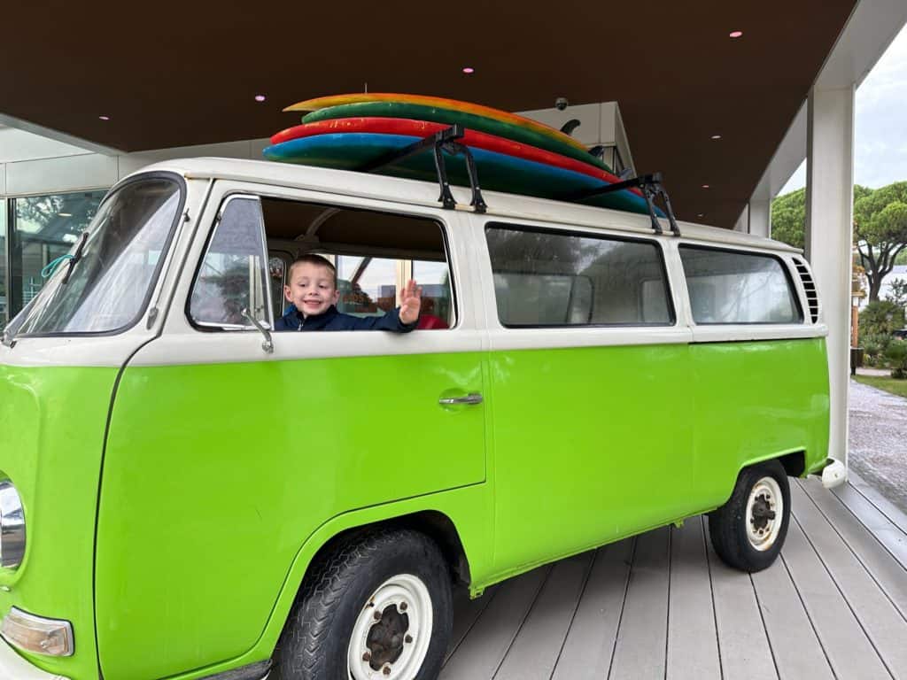 Boy waving from green van at resort in Cascais, Portugal