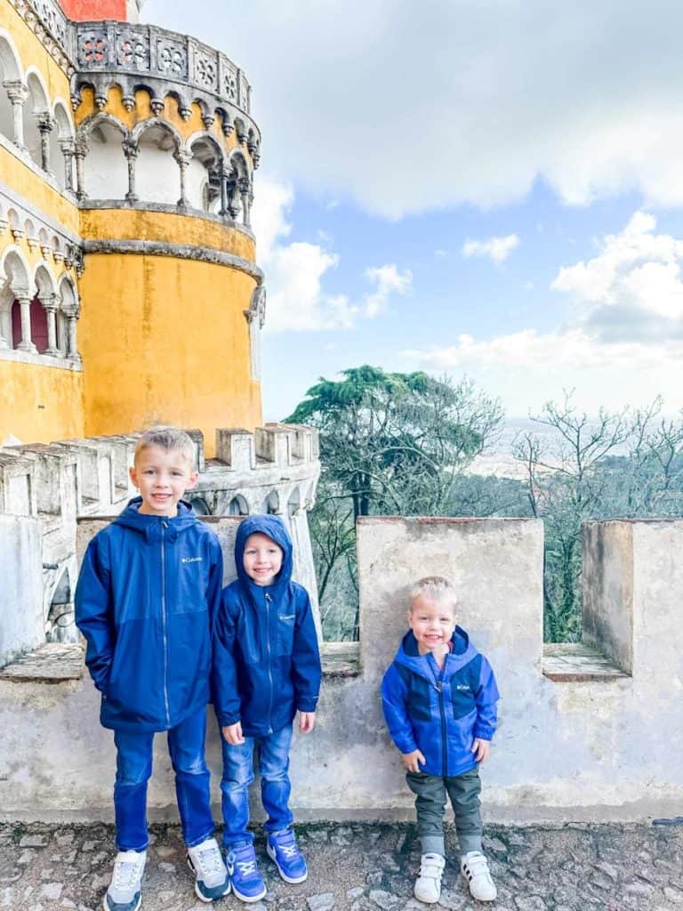 3 brothers standing on terrace of Pena Palace in Sintra, Portugal