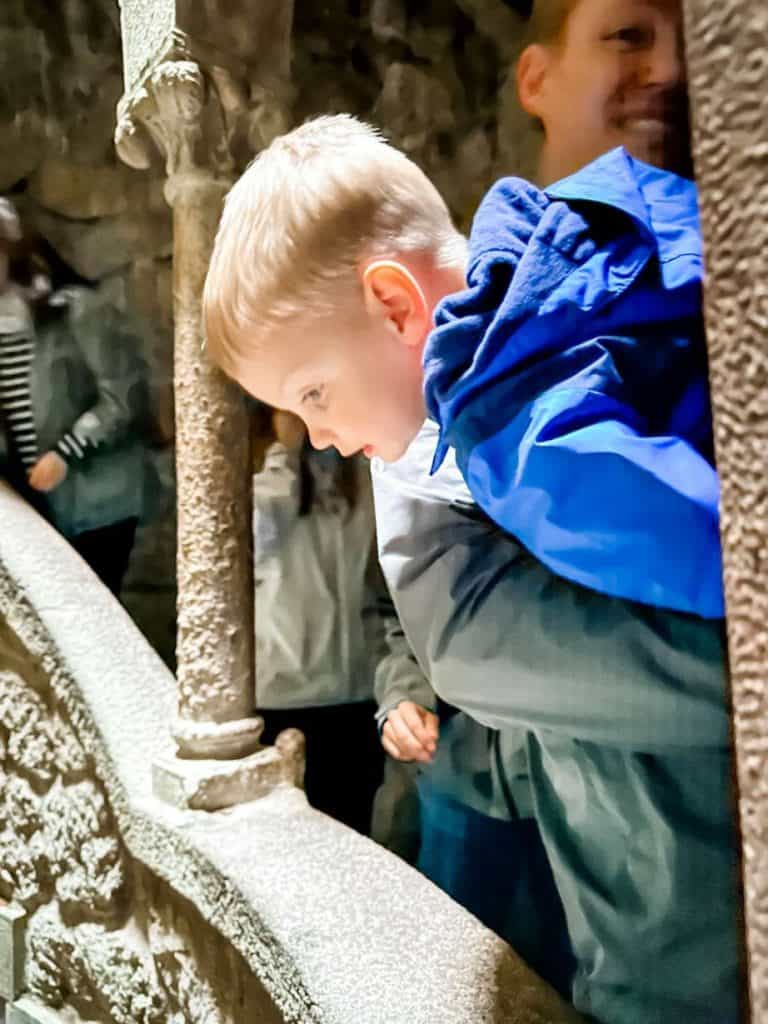 Boy looking over railing at the Initiation Well in Sintra