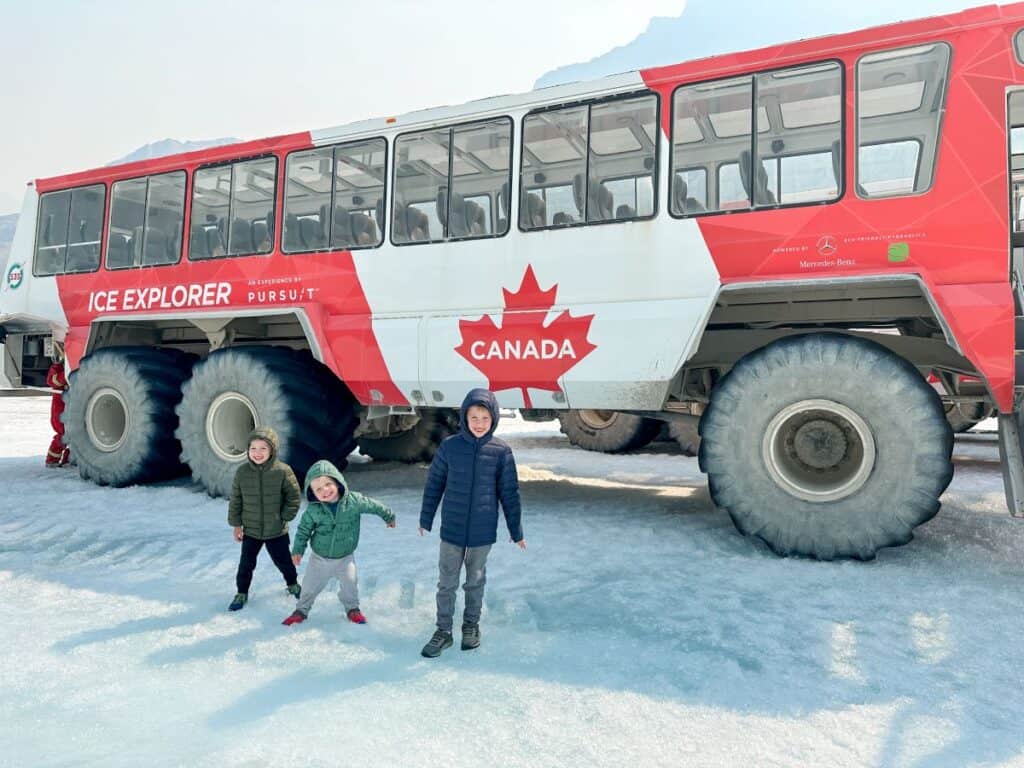Three brothers standing in front of Ice Explorer in this Columbia Icefield Adventure Review