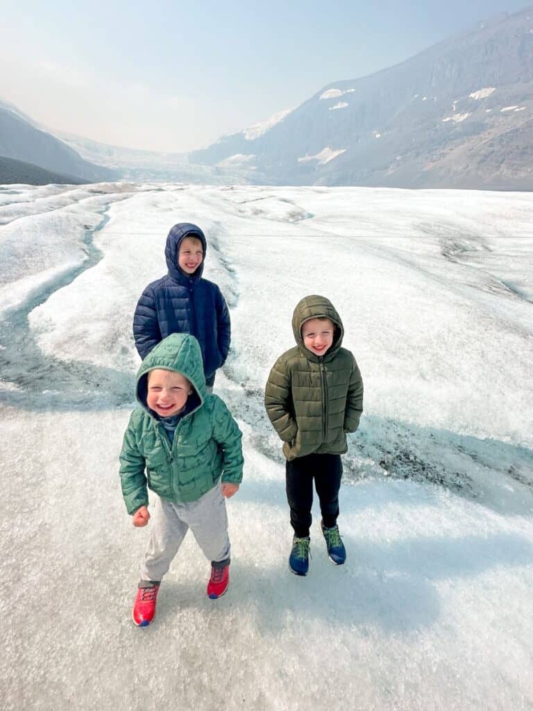 Three boys standing on Athabasca Glacier during the Columbia Icefield Adventure tour