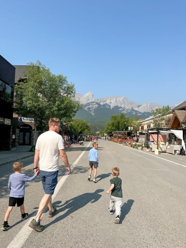 Dad and sons walking down the street in downtown Canmore