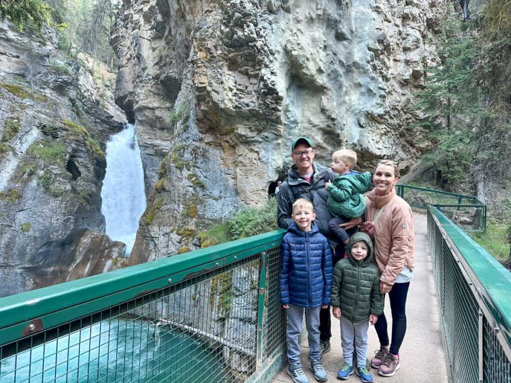 Family next to waterfall on Johnston Canyon hike with kids