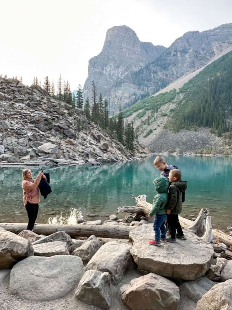 Mom taking picture of boys at Moraine Lake in Banff Canada