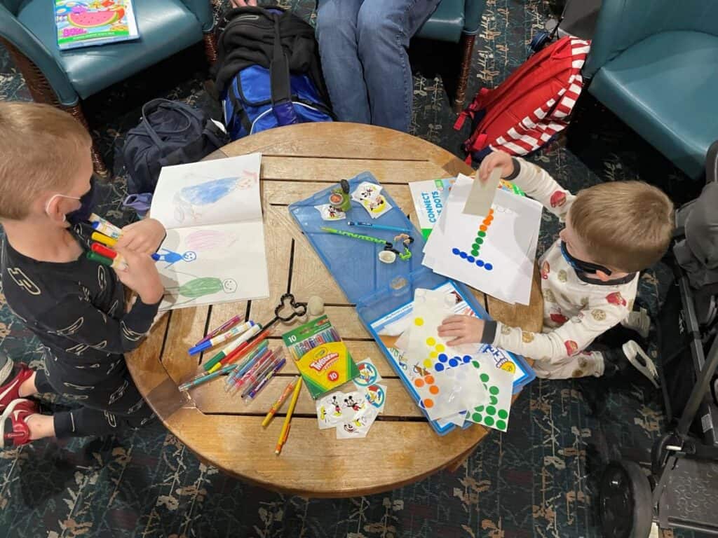 Kids at table at airport playing with activities from their travel activity pack