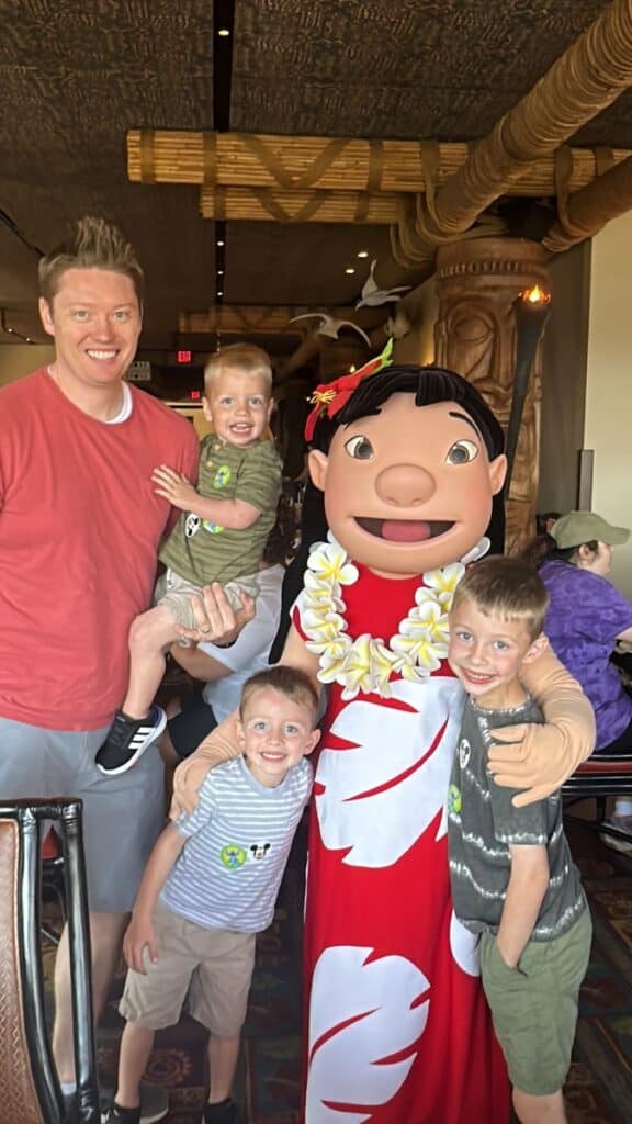 Dad and 3 sons posing with Lilo at character breakfast at 'Ohana in Disney World